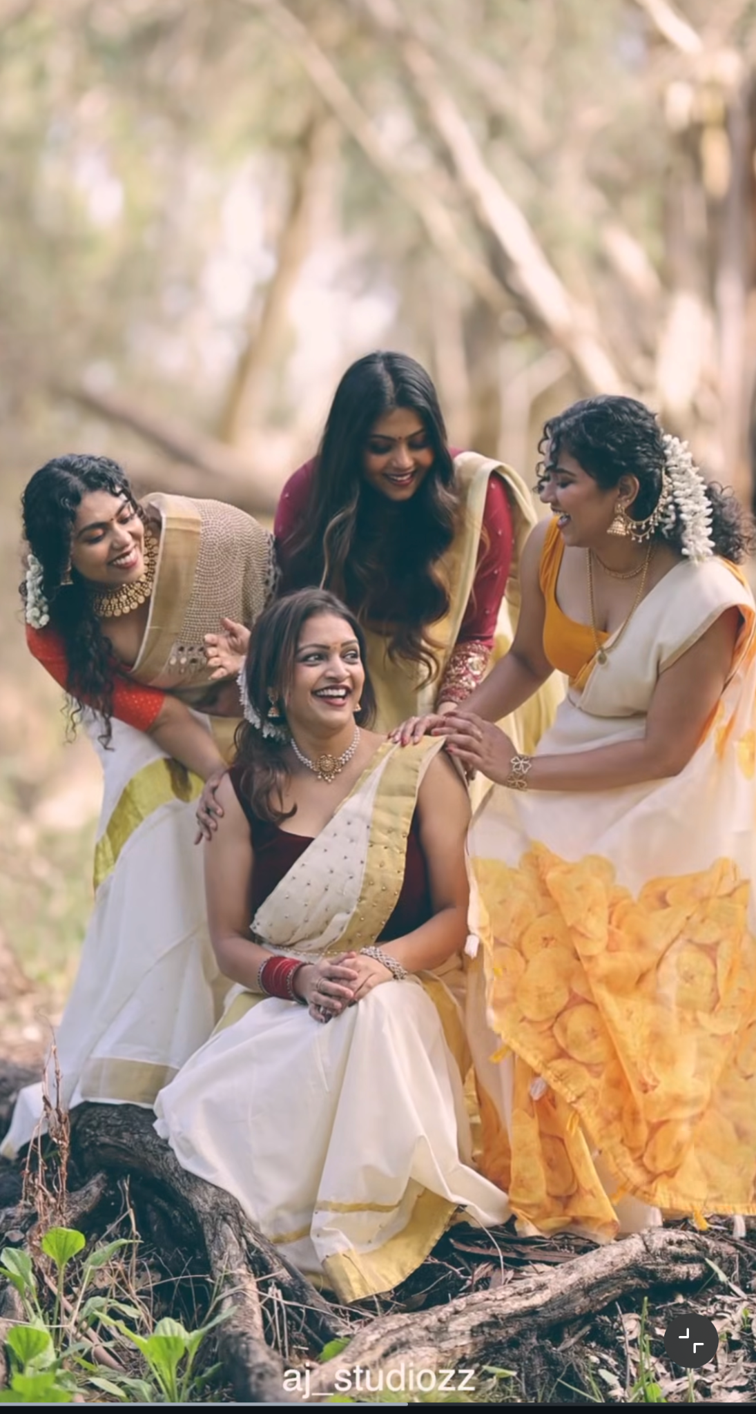 Friends sharing a joyful moment in traditional Onam attire outdoors